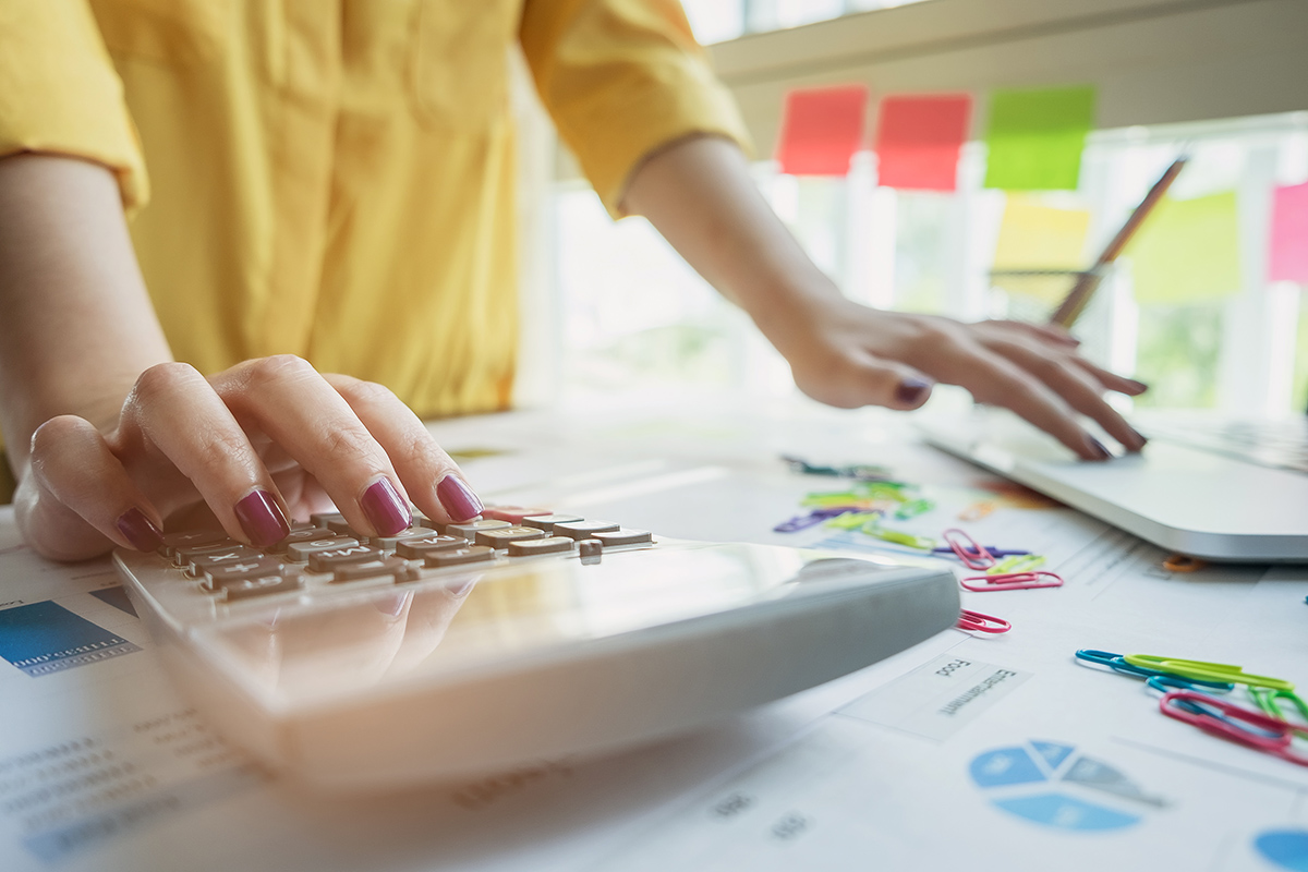 Business woman using calculator working with financial paperwork